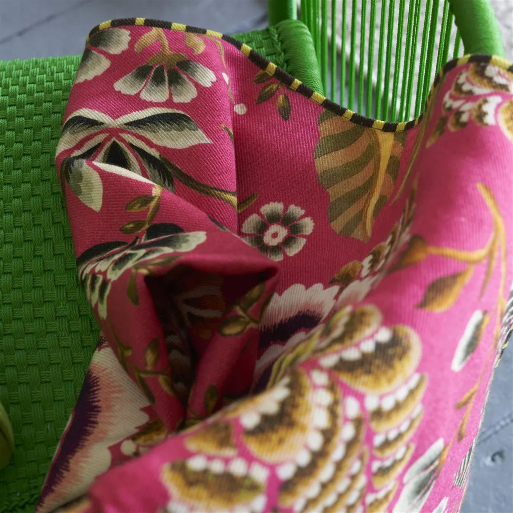Plaid en laine mérinos rose cerise motif floral damassé Designers Guild posé sur un fauteuil - Atelier Anne Lavit Lyon.